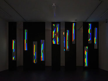 Lichtobjekt aus prismatischen Farben, das auf Schablonen geworfen wird